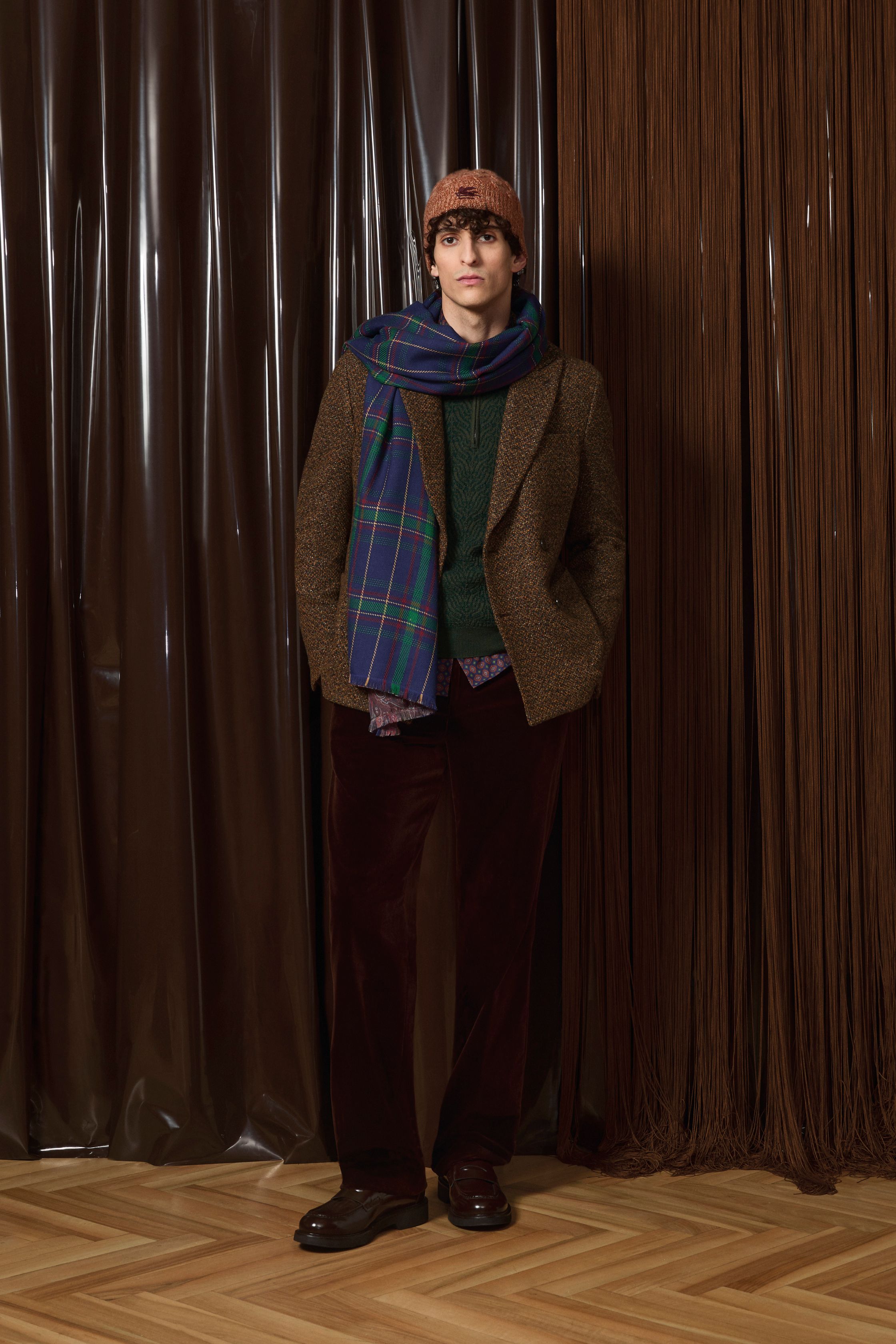 Etro 2026秋冬延续品牌标志性的波西米亚精神，却以更成熟、更男性化的方式呈现。提花针织、佩斯利纹样与复古皮革相互碰撞，营造出知识分子气质与旅行者浪漫并存的形象。整体色调趋向深棕、酒红与森林绿，使装饰性回归内敛，完成一次从“浪漫叙事”到“文化穿着”的进化-顽石频道趋势研究